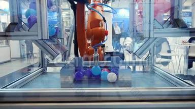 机器人机器的特写，手工重新定位小塑料五彩球。 媒体。 不同的工作机器人集合